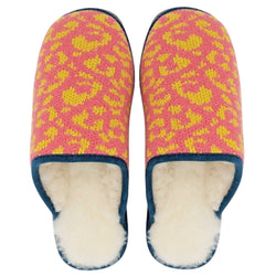 A pair of knit slip-on slippers with a pink and yellow leopard-like pattern, featuring a navy blue trim and a soft white fleece lining.