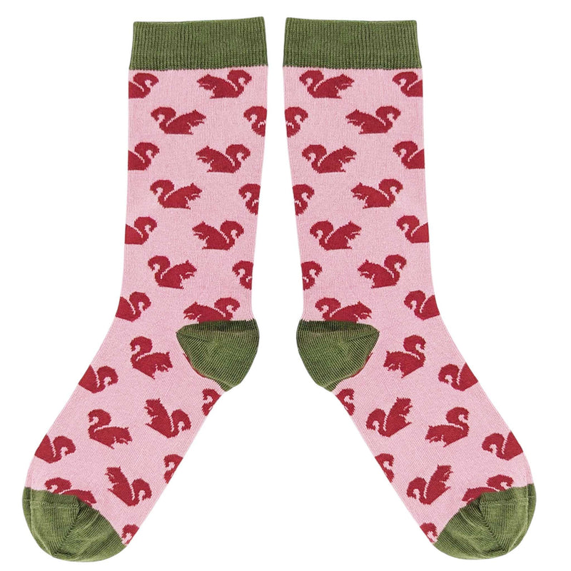Pink socks with red squirrel pattern and green accents on a white background